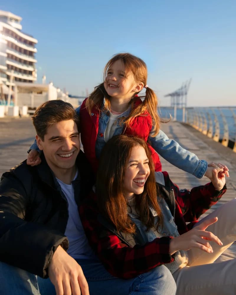 Família com duas crianças à beira-mar, num dia de sol
